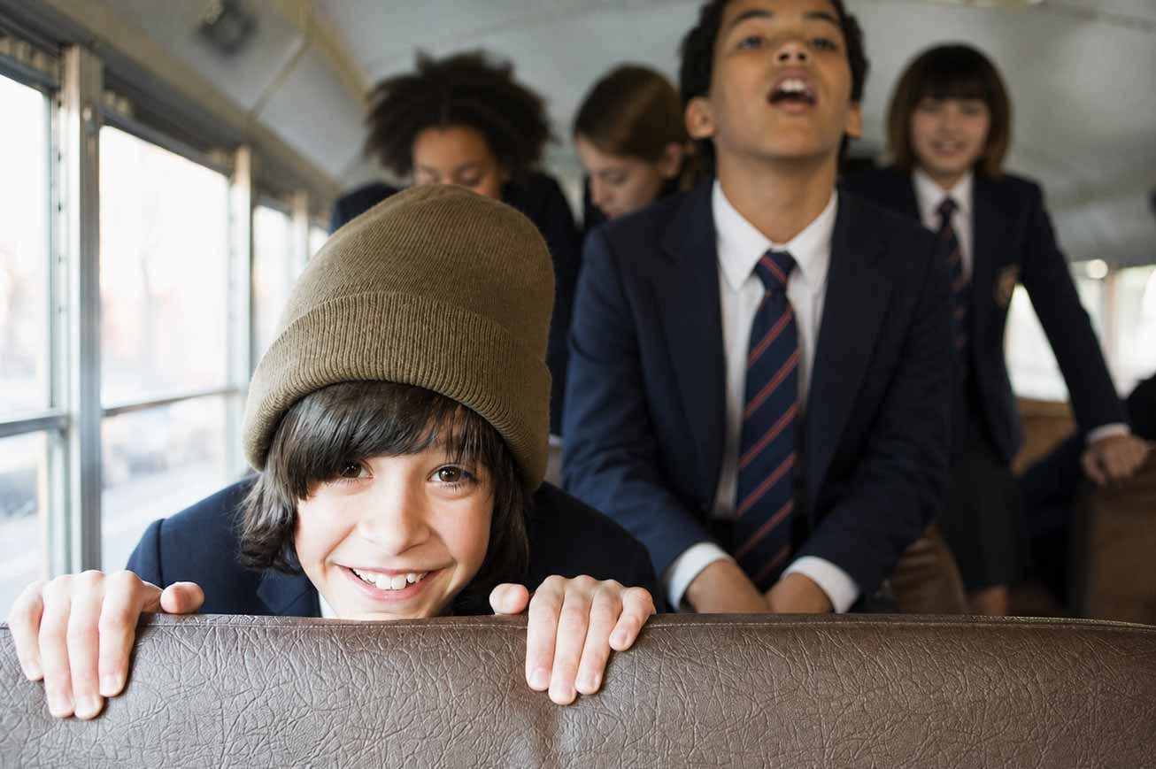 Happy school learners in uniform riding together on a Beremi scholar bus