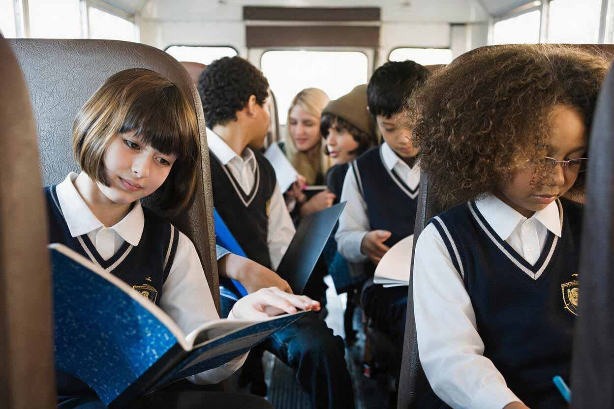 School learners in uniform reading together on a Beremi scholar bus